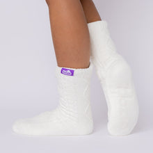 Load image into Gallery viewer, The Foozie™ Move in White, side view with one heel raised, showing the diamond cable knit and the logo tab