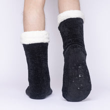 Load image into Gallery viewer, The Foozie™ in Black, back view worn by a man in Large with one foot raised to show the non-slip grips on the sole