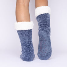 Load image into Gallery viewer, The Foozie™ in Blue, back view with one foot raised to show the non-slip grips on the sole