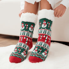 Load image into Gallery viewer, The Foozie™ Christmas Snowman slipper socks, green and red snowman and candy cane knit, hands pulling up the sherpa cuffs

