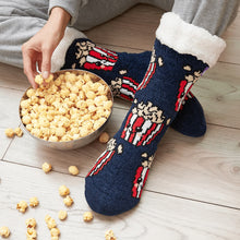 Load image into Gallery viewer, The Foozie™ Popcorn slipper socks, worn on a wooden floor beside a bowl of popcorn
