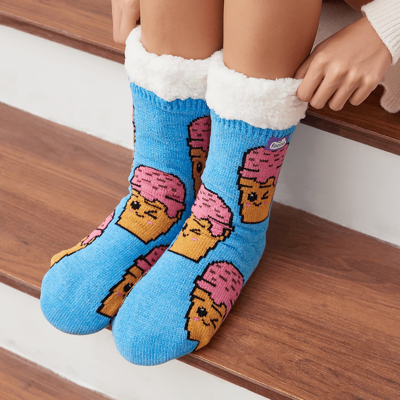 The Foozie™ Ice Cream slipper socks, close-up worn sitting on a wooden stair