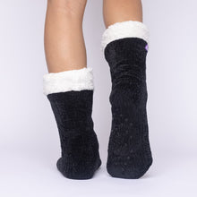 Load image into Gallery viewer, The Foozie™ in Black, back view with one foot raised to show the non-slip grips on the sole
