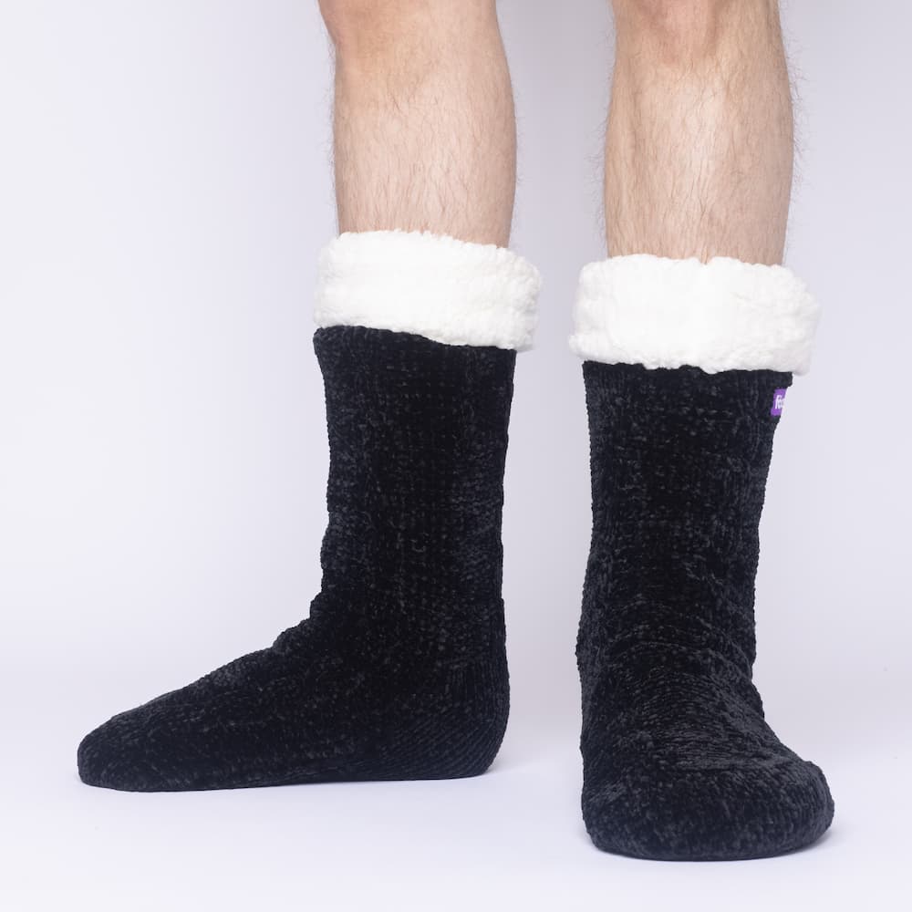 The Foozie™ in Black, front view of both feet worn by a man in Large with the sherpa cuffs folded down