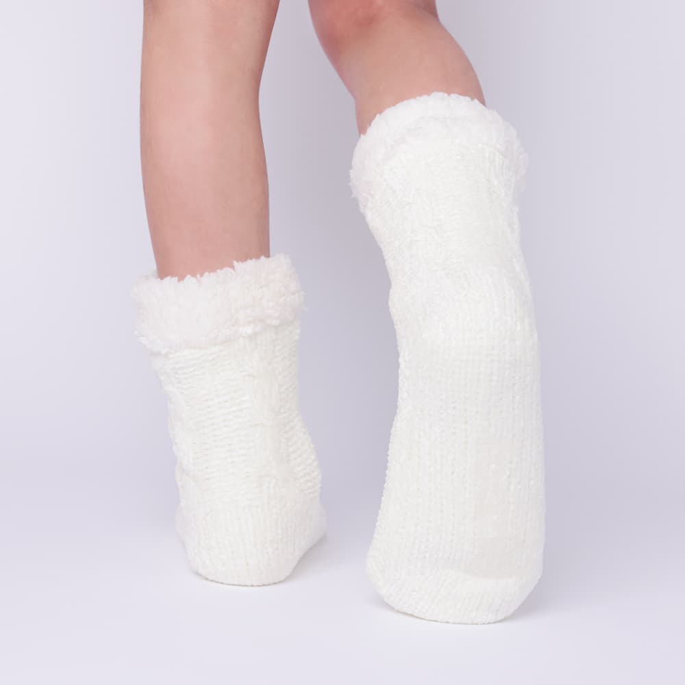 The Foozie™ in White, back view worn in Kids/Small with one foot raised to show the sole