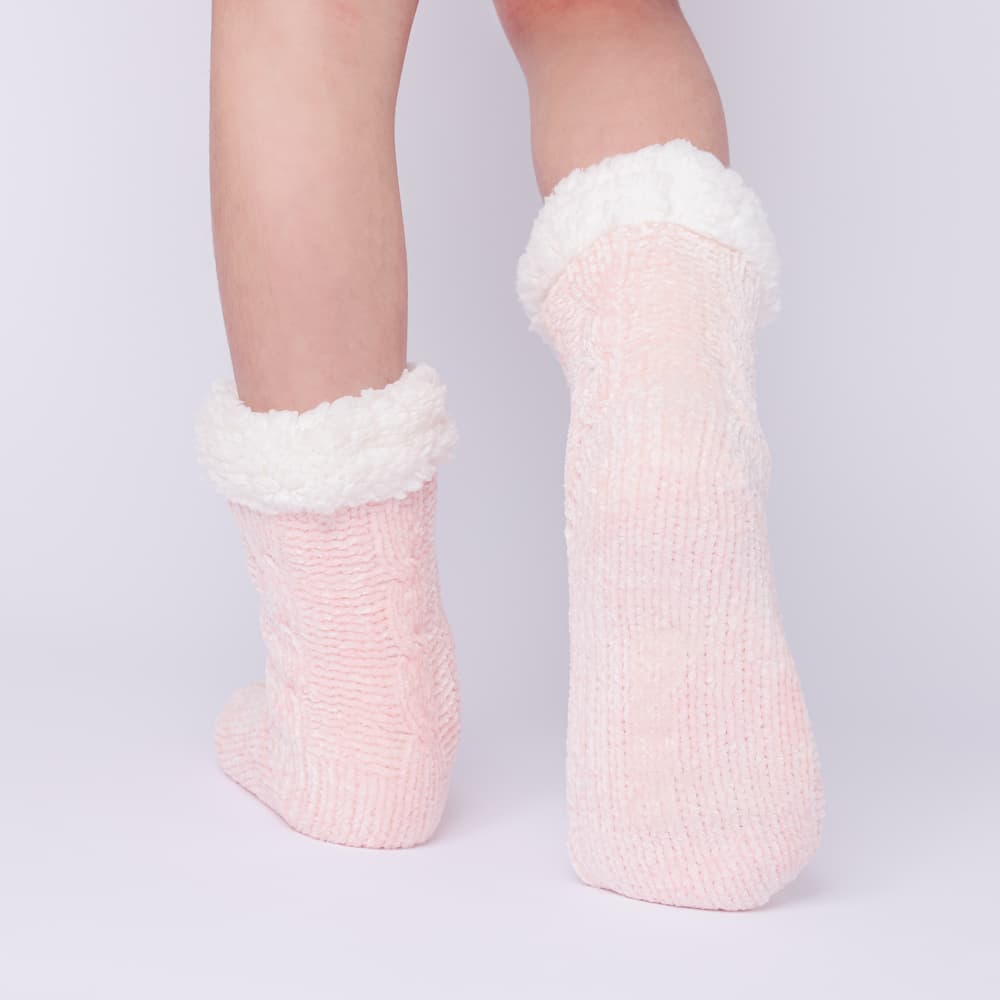 The Foozie™ in Pink, back view worn in Kids/Small with one foot raised to show the sole