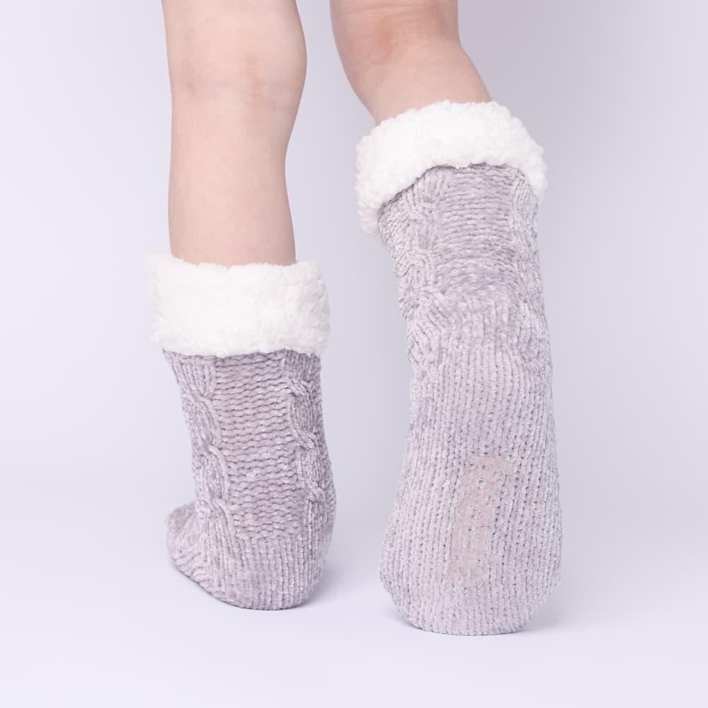 The Foozie™ in Light Gray, back view worn in Kids/Small with one foot raised to show the non-slip grips on the sole