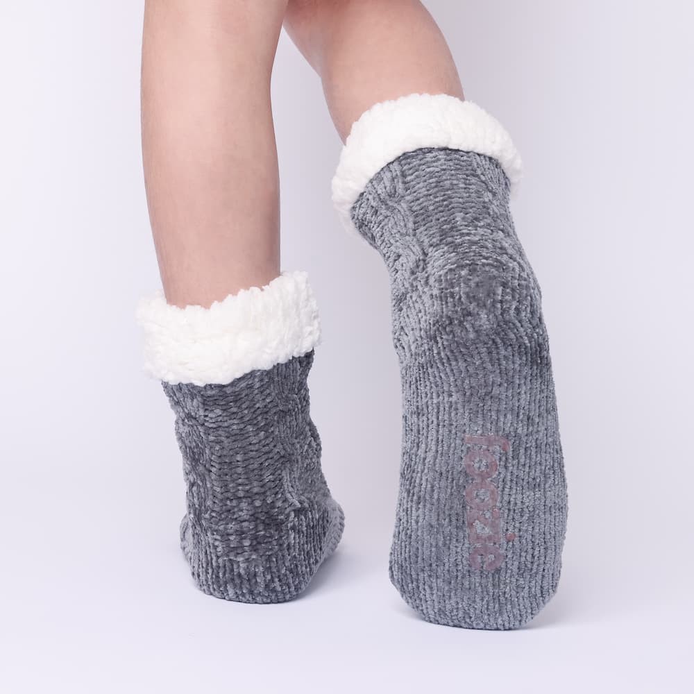 The Foozie™ in Dark Gray, back view worn in Kids/Small with one foot raised to show the non-slip grips on the sole